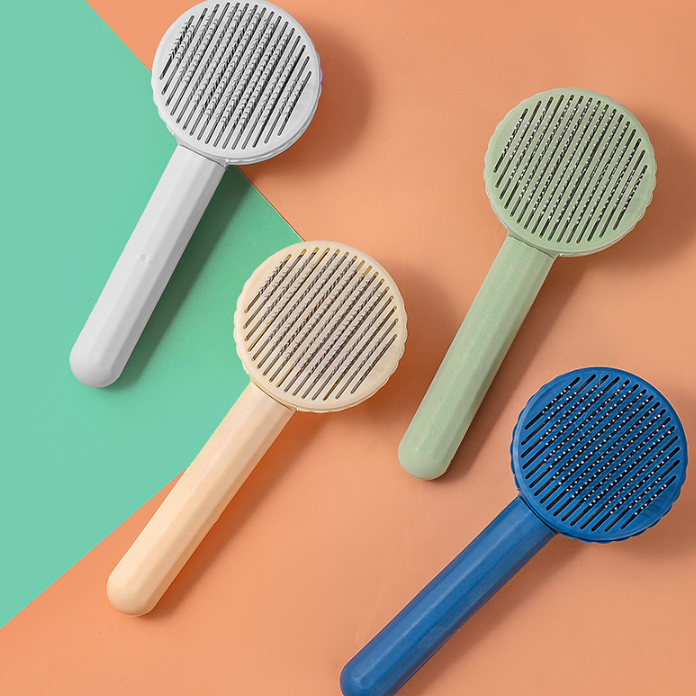 Self-cleaning slicker brush, push-button release